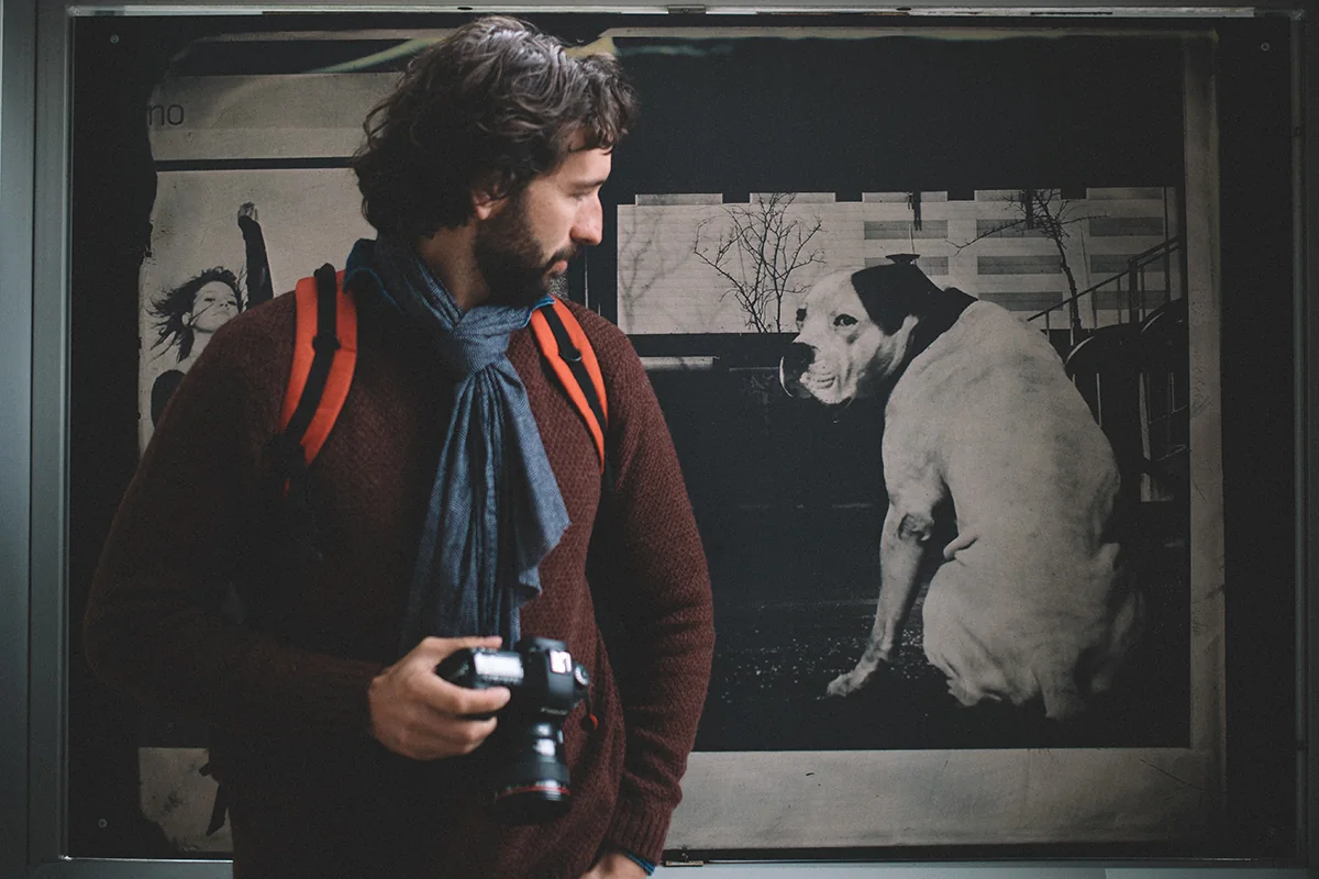 Yves Schüpbach mit Kamera vor einem grossen Schwarzweiss-Foto eines Hundes